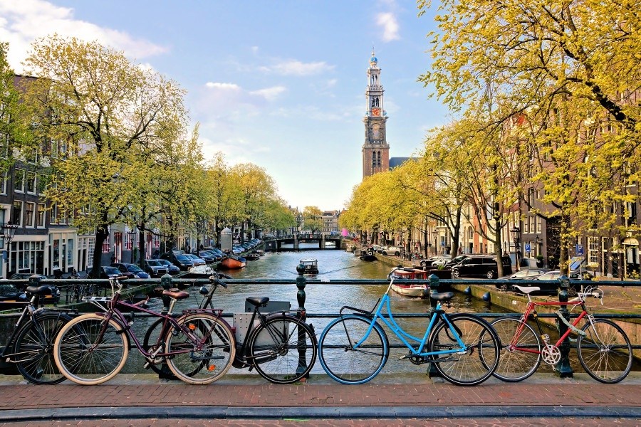 Rowery zaparkowane nad kanałem w Amsterdamie, symbol codziennego życia w Holandii